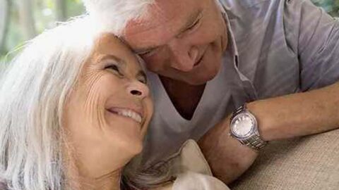 elderly man and woman smiling heartily together