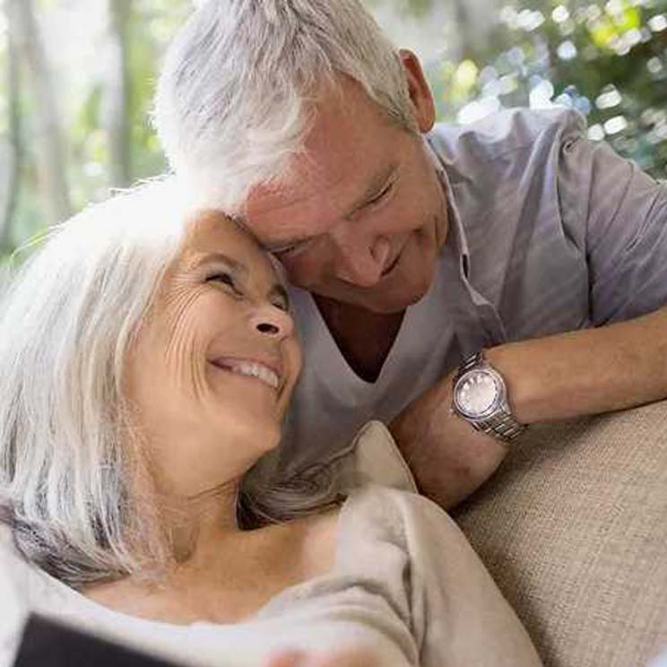 elderly man and woman smiling heartily together