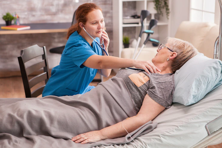 a female doctor using stethoscope to check senior woman's heart.