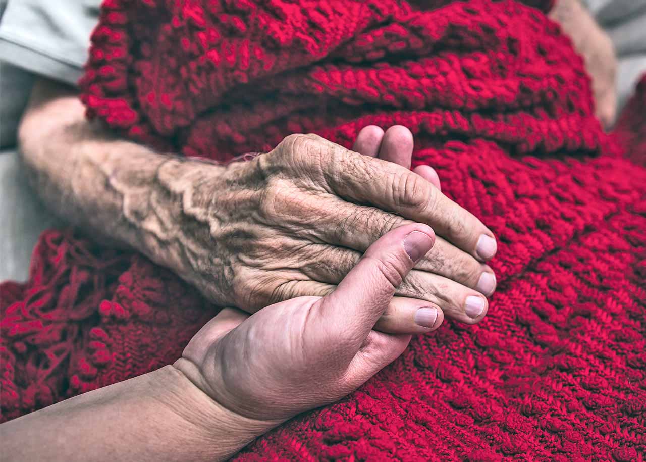 A caregiver providing end of life care for an elderly patient