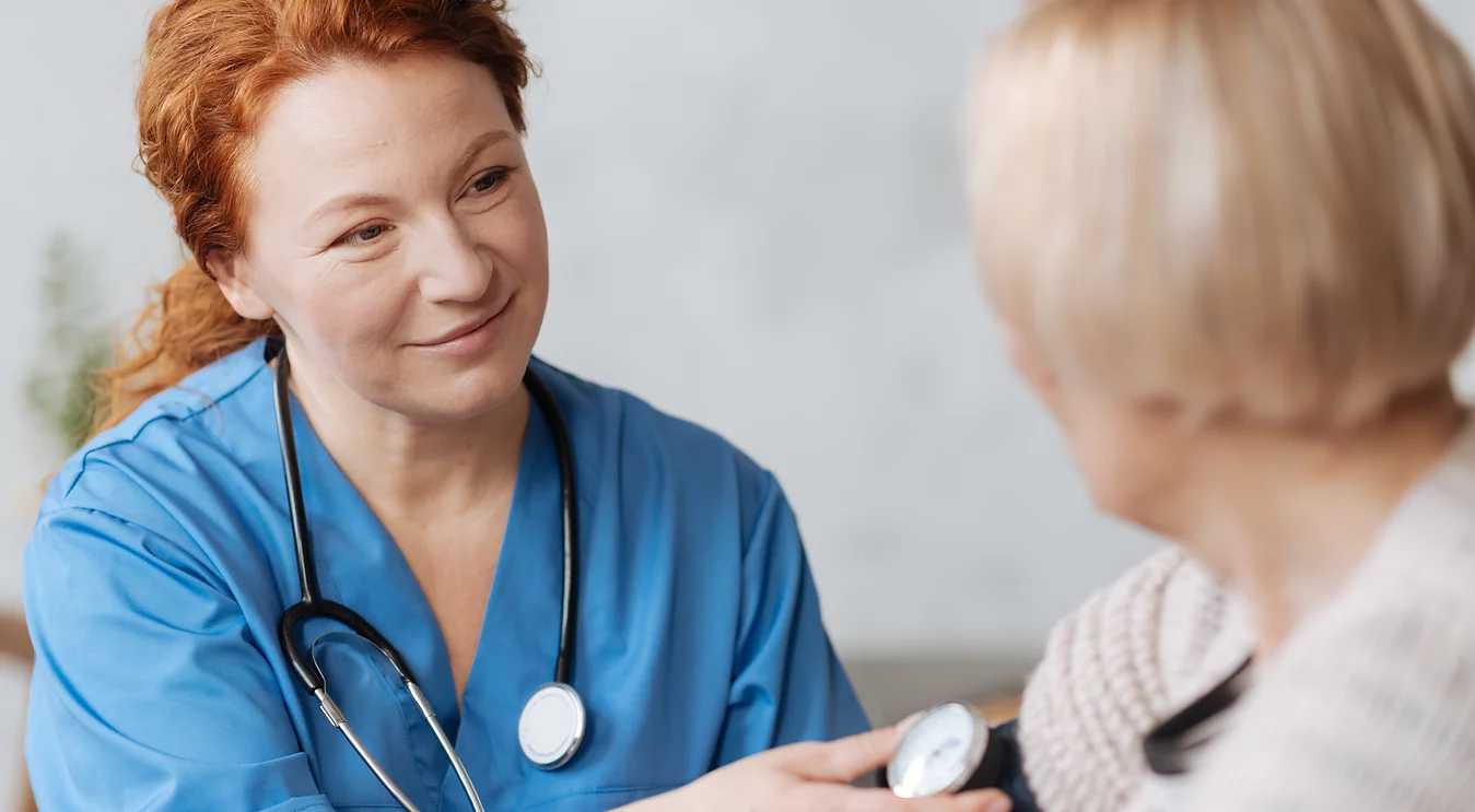 a nurse checking an elderly woman's blood pressure