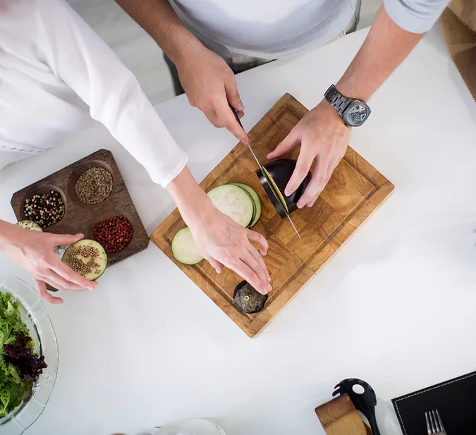 as part of the service we offer at real home care, a live-in carer is preparing a meal for a client